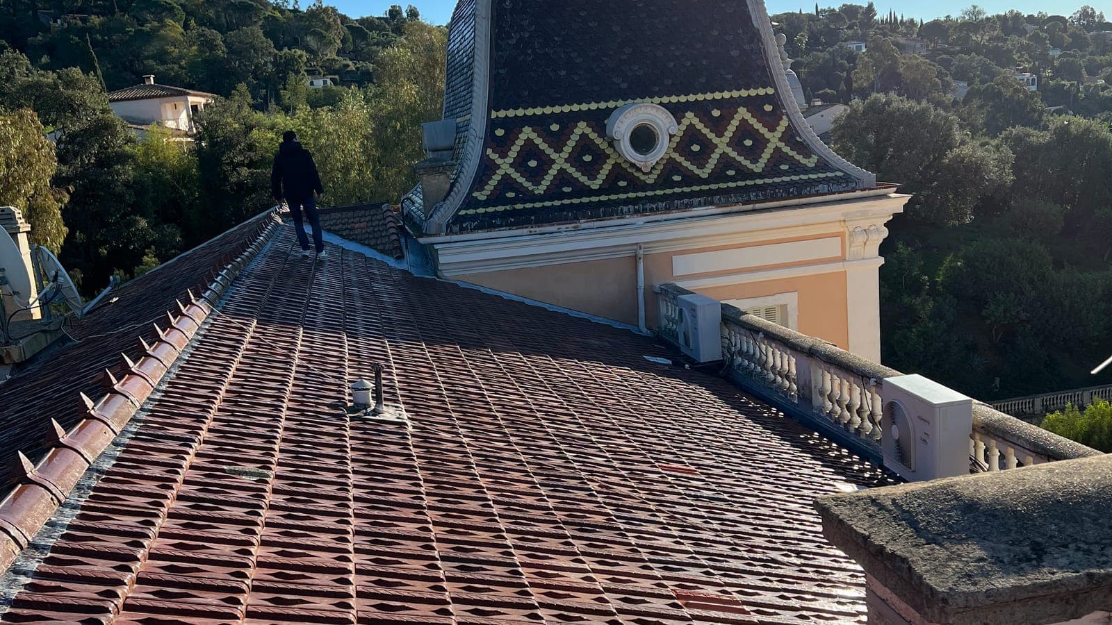 Long versant en tuiles mécaniques d'une demeure ancienne, dôme à motifs et balustrade